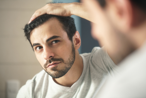 Latino,person,with,beard,grooming,in,bathroom,at,home.,white